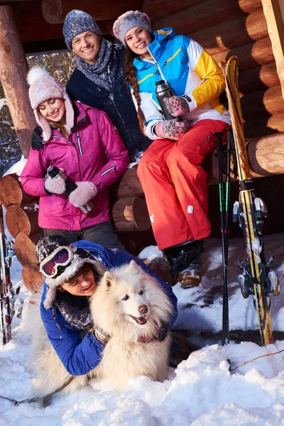 Fröhliche Freunde mit Hund verbringen Winterurlaub zusammen — Stockfoto