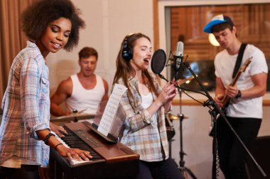 Multiracial music band performing in a recording studio clipart