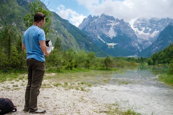 Man controls drone with mountains on background. — Stock Photo, Image