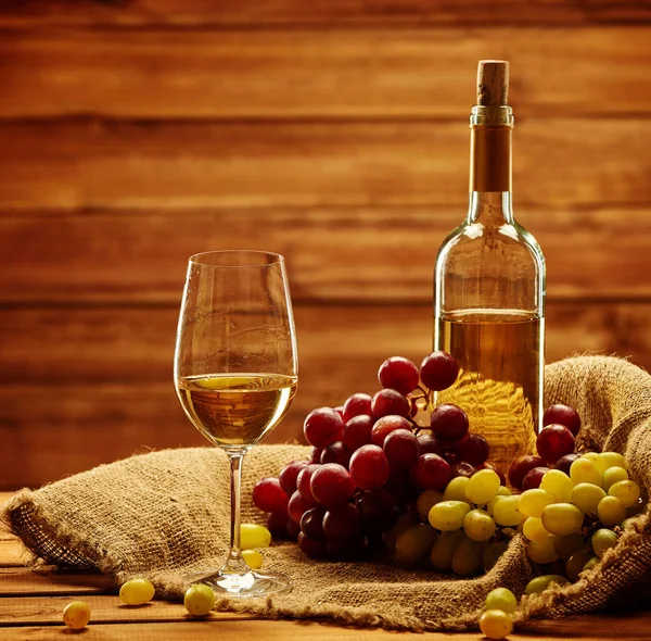Botella de vino blanco, copa y uva en un saco —  Fotos de Stock