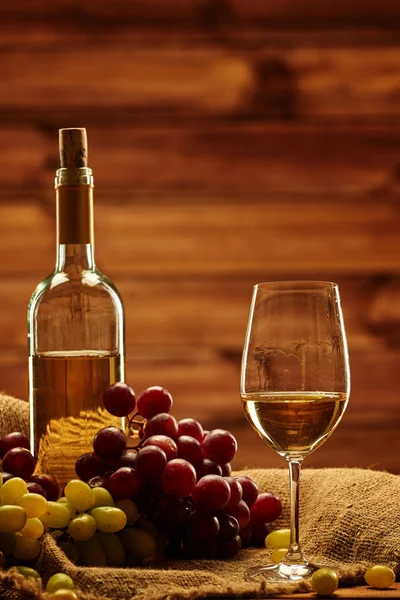 Garrafa de vinho branco, copo e uva em um saco — Fotografia de Stock