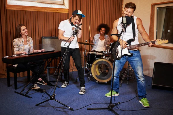 Banda de música multirracial se apresentando em um estúdio de gravação — Fotografia de Stock