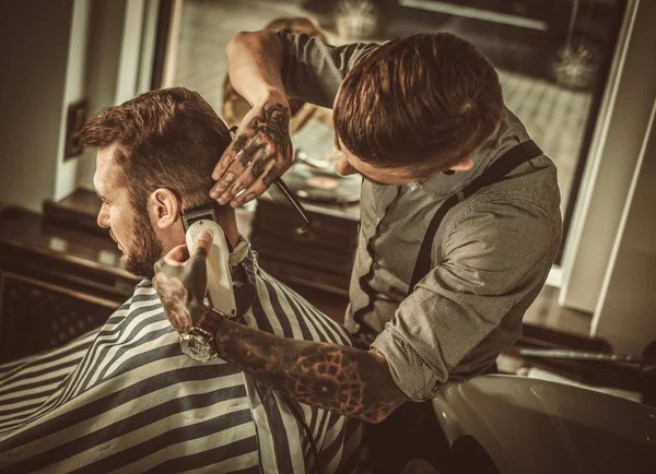 Selbstbewusster Mann besucht Friseur im Friseursalon. — Stockfoto