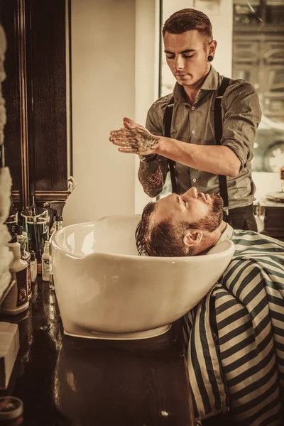 Hombre seguro visitando peluquero en la peluquería . — Foto de Stock