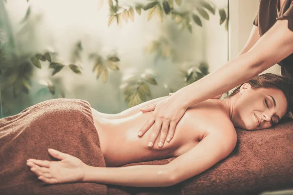 Młoda kobieta o masaż w salonie spa. — Zdjęcie stockowe