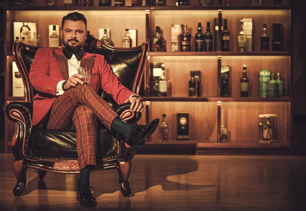 Uomo elegante stravagante con un bicchiere di whisky — Foto Stock