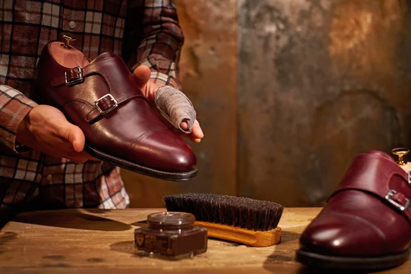 Человек чистит ботинки тряпкой — стоковое фото