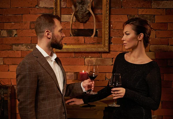 居心地の良いインテリアに赤ワインのグラスと身なりのカップル — ストック写真
