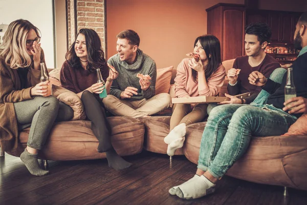 Grupo de jovens amigos multi étnicos comer pizza em casa interior — Fotografia de Stock