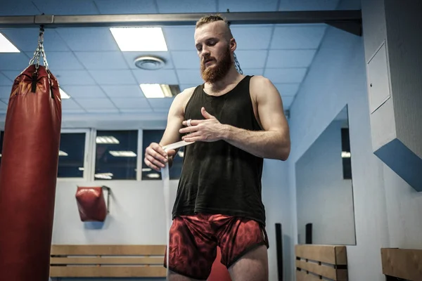 Combatiente preparándose para el entrenamiento, envolviendo las manos con envolturas de boxeo —  Fotos de Stock