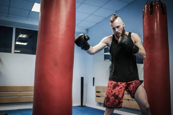 Vechter training aan de bokszak op sportschool — Stockfoto