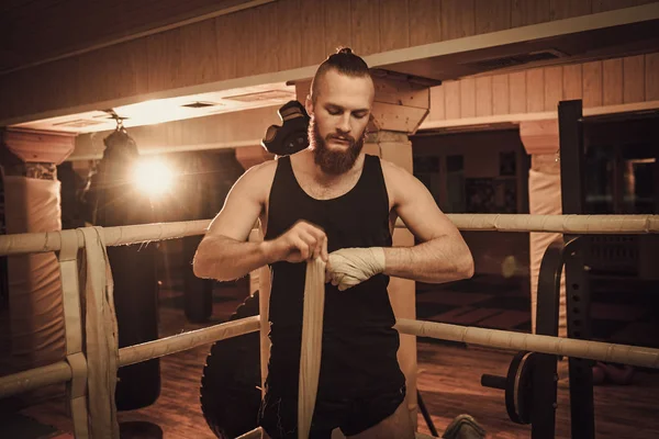 Fighter förbereder för yrkesutbildning, inslagning händer med boxing wraps — Stockfoto