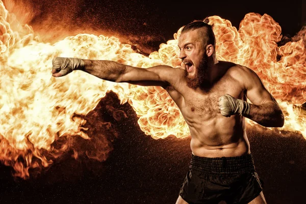 Combatiente profesional shadowboxing con fuego y chispas en el fondo — Foto de Stock