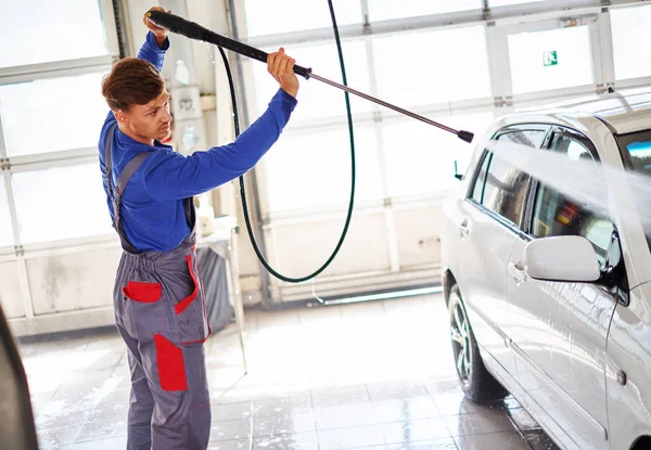 Uomo lavoratore lavaggio auto su un autolavaggio — Foto Stock