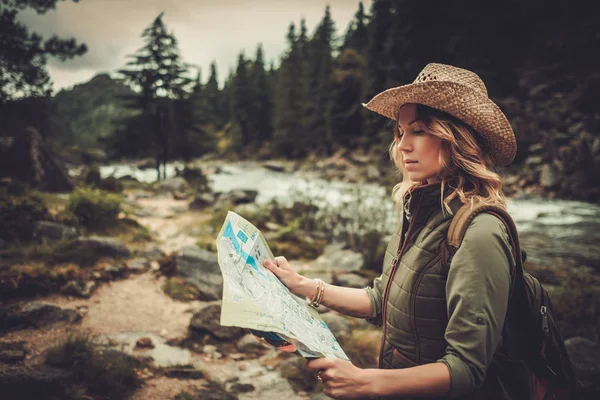 Woman hiker, searching right direction on map