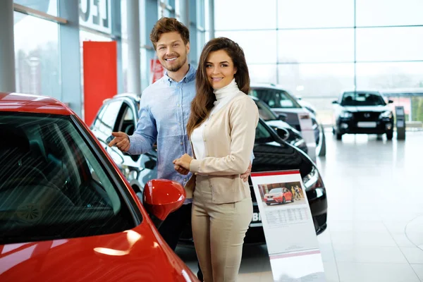 Koppel op zoek naar een nieuwe auto bij de dealer-showroom — Stockfoto