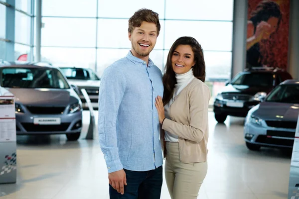 Koppel op zoek naar een nieuwe auto bij de dealer-showroom — Stockfoto