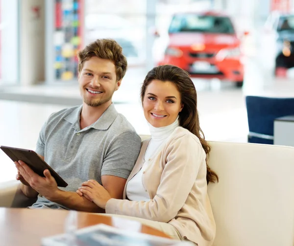 Casal procurando um carro novo no showroom concessionária — Fotografia de Stock