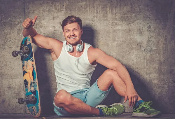 Handsome young man with skateboard outdoors — Stock Photo, Image