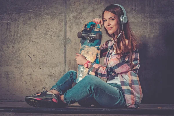 Schöne junge Frau mit Skateboard im Freien — Stockfoto