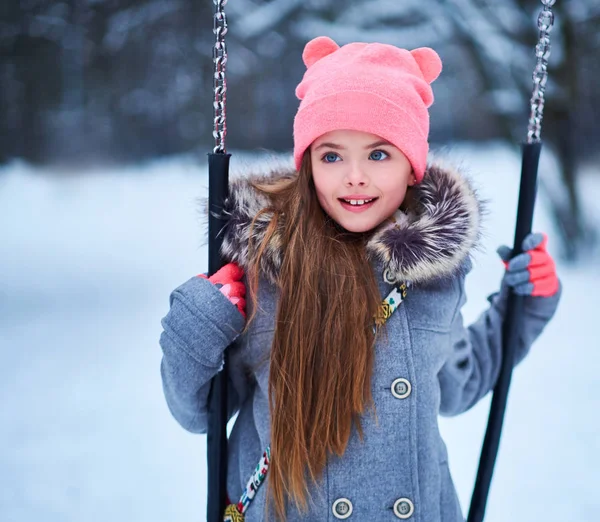 Menina encantadora no balanço no inverno nevado — Fotografia de Stock