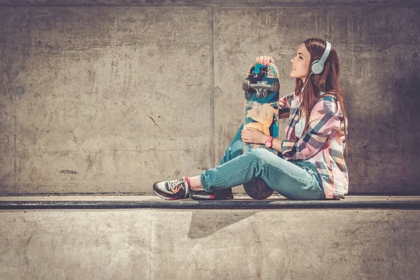 Mooie jonge vrouw met skateboard buitenshuis — Stockfoto
