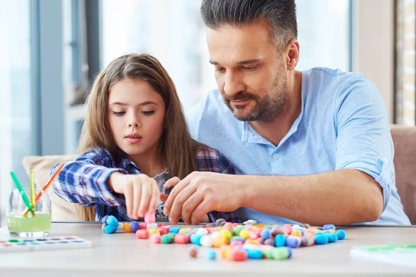 Hermosa niña con su padre jugando con el conjunto de colores para la creatividad — Foto de Stock