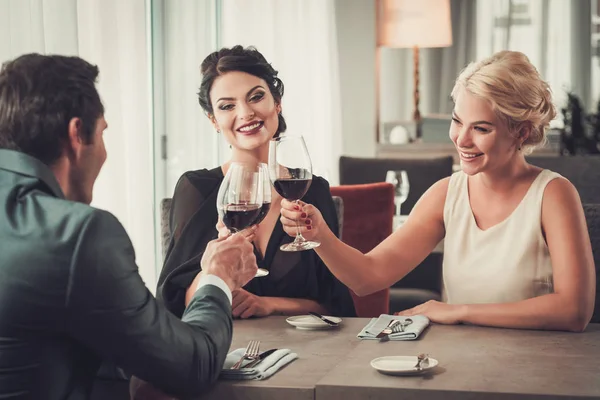 Grupa ludzi zamożnych sakiewkach brzęczały szklanki czerwonego wina w restauracji — Zdjęcie stockowe