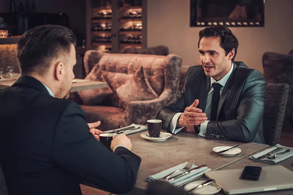 Два уверенных бизнесмена обедают в ресторане — стоковое фото
