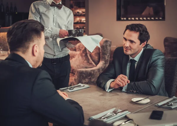 Två säkra affärsmän har affärslunch i restaurangen — Stockfoto