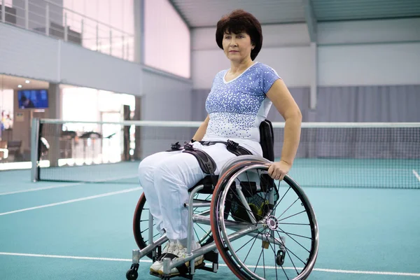 Άτομα με ειδικές ανάγκες ώριμη γυναίκα σε αναπηρικό καροτσάκι στο γήπεδο τένις — Φωτογραφία Αρχείου