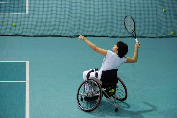 Disabled mature woman on wheelchair playing tennis on tennis court — Stock Photo, Image