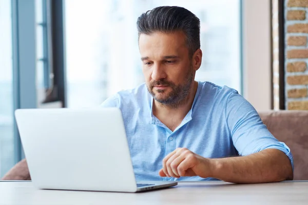 Przystojny człowiek korzystający z laptopa w domu — Zdjęcie stockowe