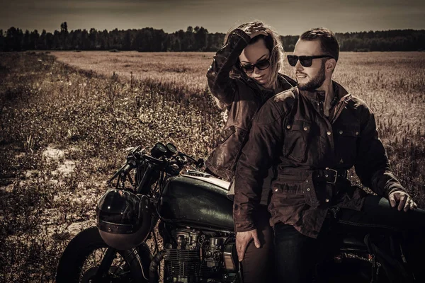 Jeune, élégant couple de coureur de café sur les motos personnalisées vintage dans le domaine — Photo