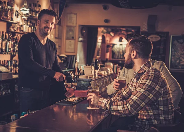 Veselá staří přátelé pití točené pivo v baru v hospodě. — Stock fotografie