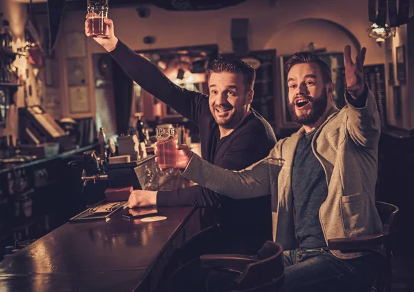 Веселі старі друзі п'ють пиво за барною стійкою в пабі . — стокове фото