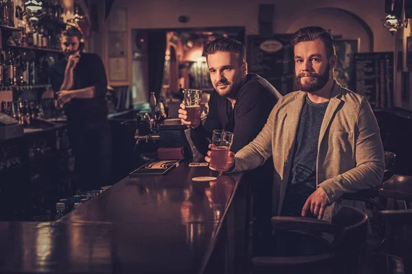 Glada gamla vänner dricka öl på bardisk i pub. — Stockfoto