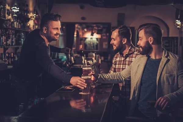 Veselá staří přátelé pití točené pivo v baru v hospodě. — Stock fotografie