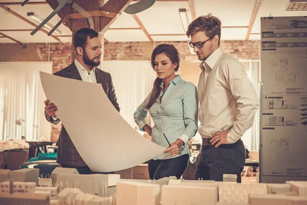 Equipo de ingenieros confiados trabajando juntos en un estudio de arquitectura . — Foto de Stock