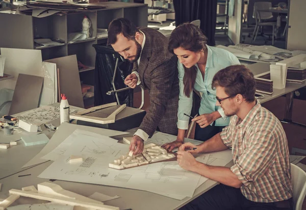 Une équipe confiante d'ingénieurs travaillant ensemble dans un studio d'architecte . — Photo