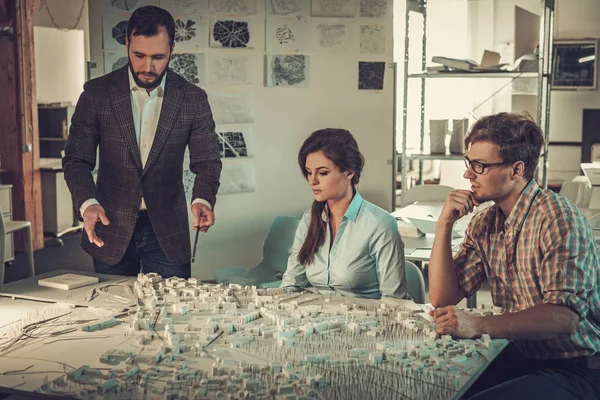 Equipo de ingenieros confiados trabajando juntos en un estudio de arquitectura . — Foto de Stock