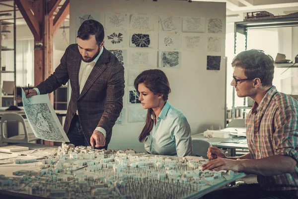 Equipo de ingenieros confiados trabajando juntos en un estudio de arquitectura . — Foto de Stock