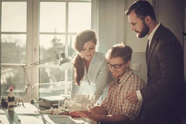 Equipo de ingenieros confiados trabajando juntos en un estudio de arquitectura . — Foto de Stock