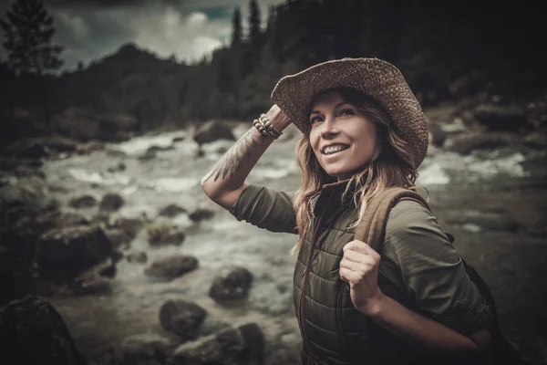 Beautiful woman hiker near wild mountain river. — Stock Photo, Image