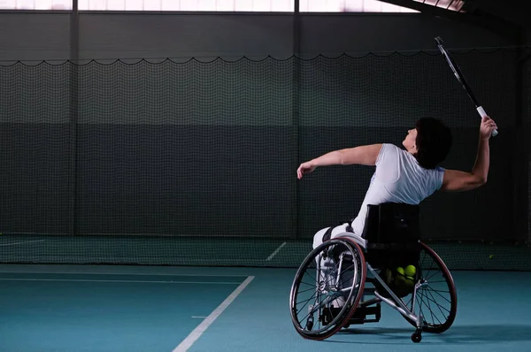 Disabled mature woman on wheelchair playing tennis on tennis court. — Stock Photo, Image