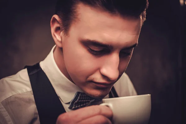 Απότομη ντυμένος άντρας φορώντας γιλέκο με ένα φλιτζάνι καφέ — Φωτογραφία Αρχείου
