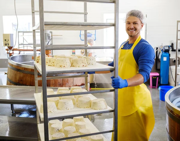Handsome cheesemaker making curd cheese in his factory — Stock Photo, Image