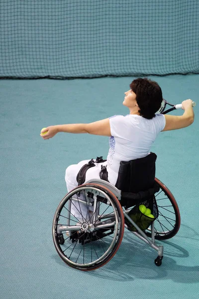 Άτομα με ειδικές ανάγκες ώριμη γυναίκα σε αναπηρικό καροτσάκι να παίζει τένις στο γήπεδο τένις. — Φωτογραφία Αρχείου