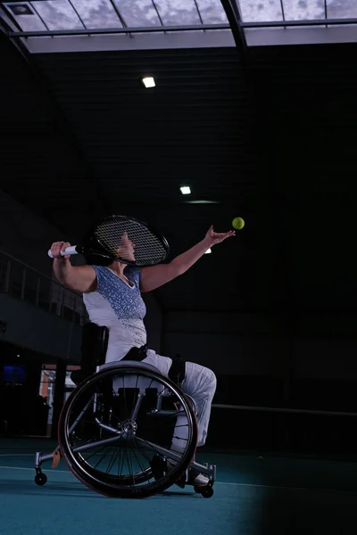 Зріла жінка на інвалідному візку грає в теніс на тенісному корті . — стокове фото