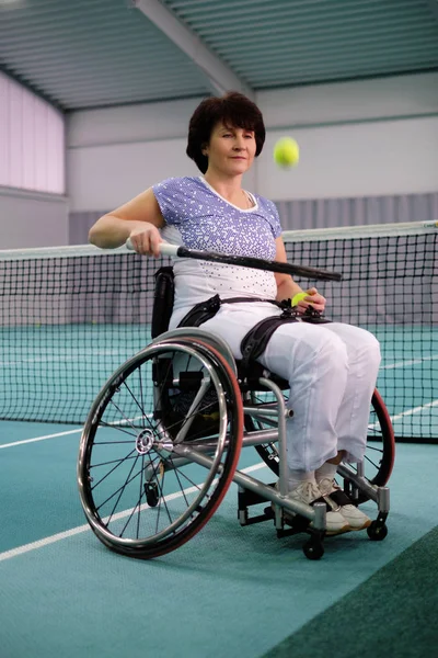 Mensen met een handicap, oudere vrouw op rolstoel tennissen op de tennisbaan. — Stockfoto